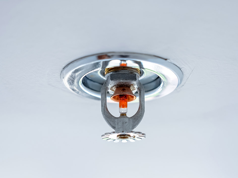 automatic head fire sprinkler extinguisher on white ceiling light window view selected focus on sprinkler