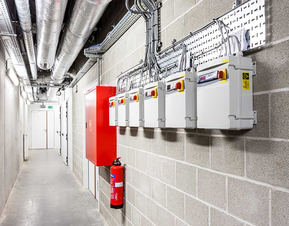 there are several pipes and a fire extinguisher in the basement