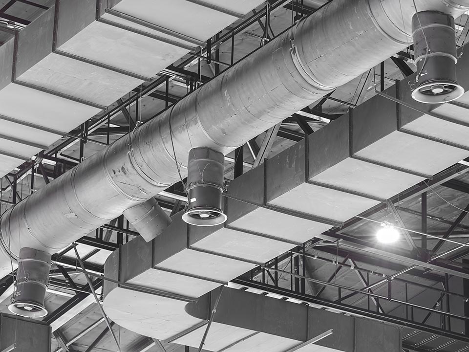 HVAC Duct Cleaning, Ventilation pipes in silver insulation material hanging from the ceiling inside new building.